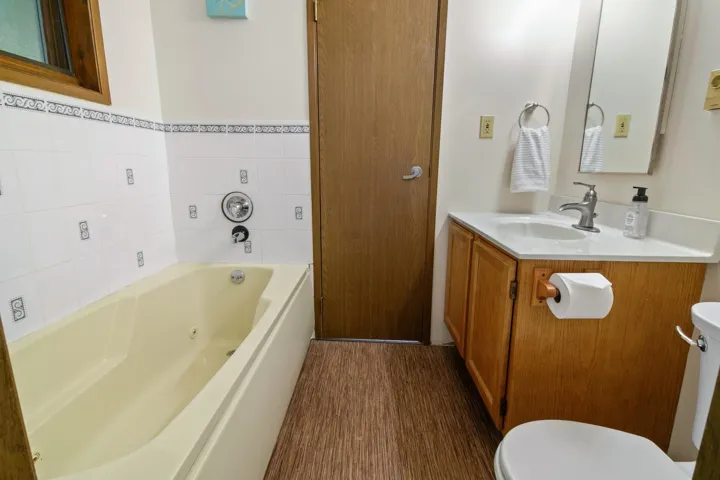 Full bath featuring toilet, a bath, and vanity