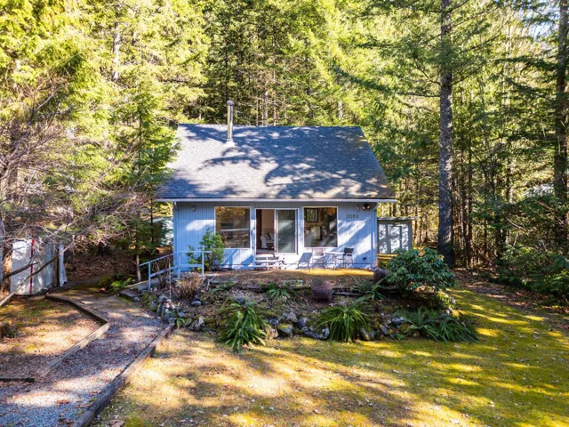 View of front facade featuring a forest view and a front yard