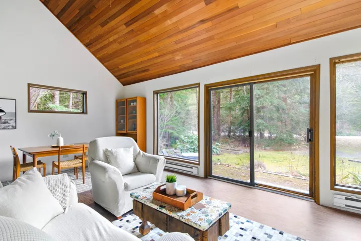 Living area with wood ceiling, high vaulted ceiling, and wood finished floors