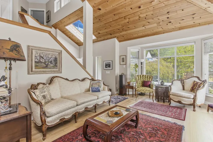 Vaulted wood-paneled ceiling with skylight in an open-concept living area