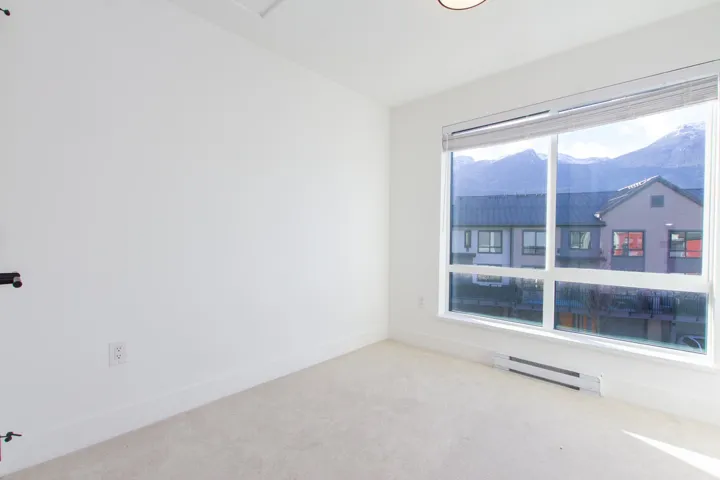 Unfurnished room featuring a baseboard radiator, carpet, and a mountain view