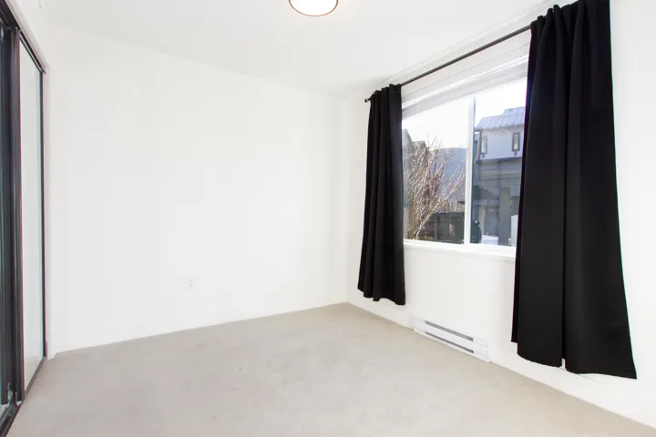 Carpeted empty room featuring a baseboard radiator and baseboards
