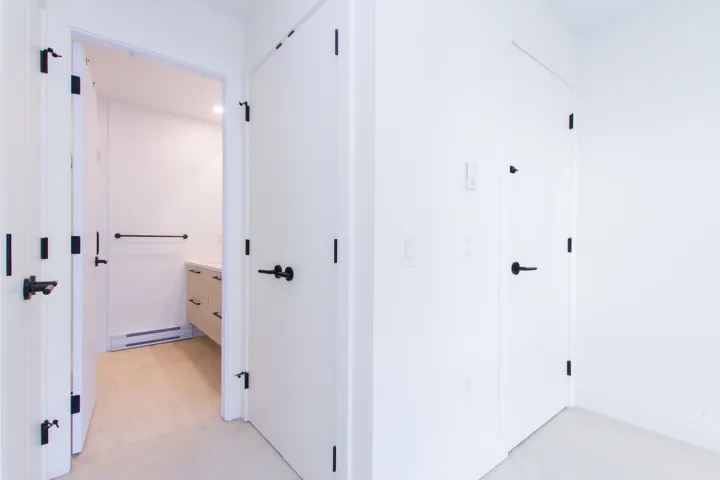 Hallway featuring a baseboard heating unit and light carpet
