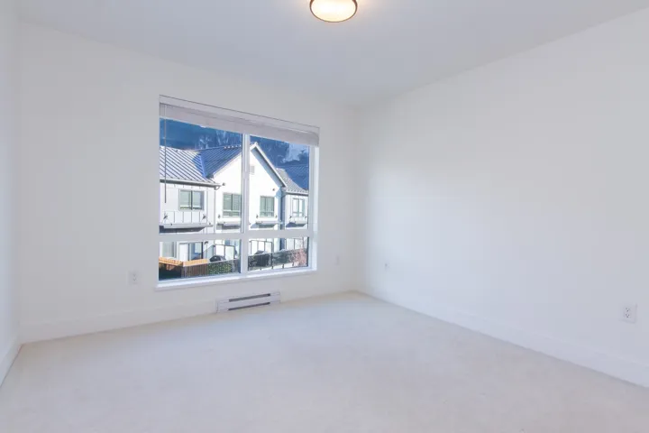Carpeted spare room featuring baseboards and a baseboard radiator
