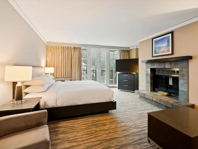 Bedroom with carpet floors, crown molding, access to exterior, and a tiled fireplace