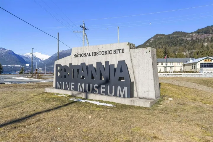 Community sign with a mountain view and a lawn