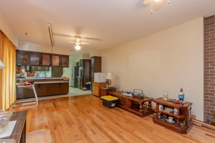 Kitchen featuring a ceiling fan, light wood-style floors, freestanding refrigerator, and a peninsula