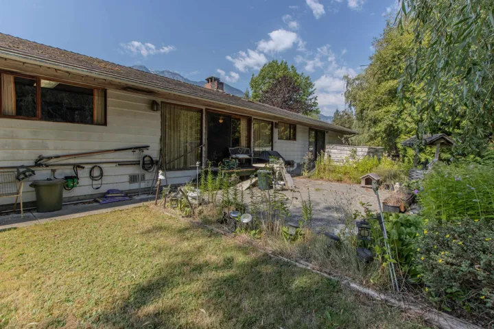 Rear view of property featuring a chimney and a yard