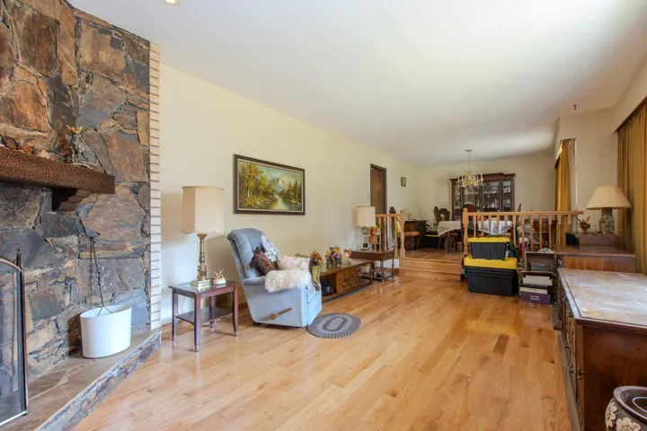Living area with light wood finished floors, a chandelier, and a fireplace