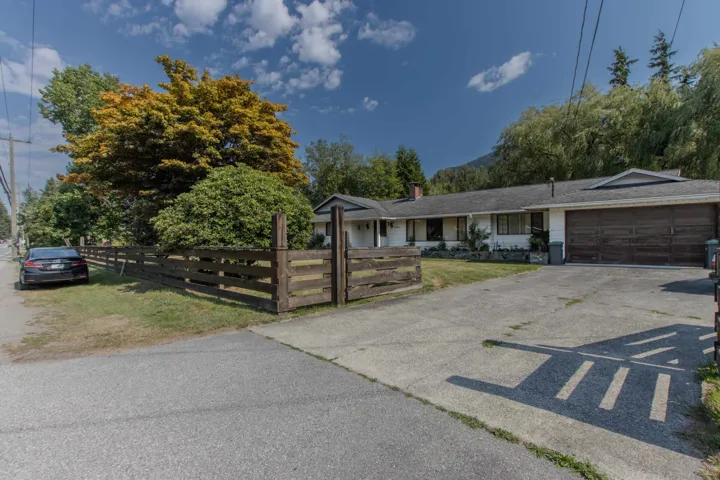 Single story home with a fenced front yard, driveway, an attached garage, and a chimney