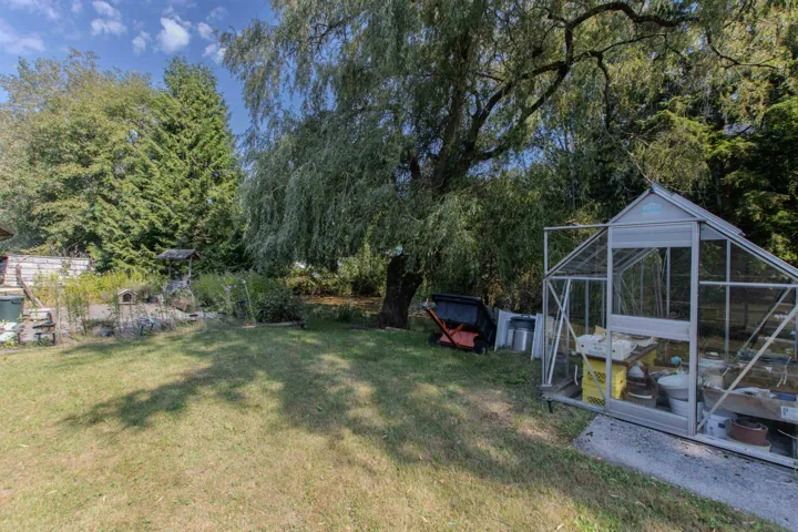 View of green lawn featuring an outdoor structure, an exterior structure, and view of scattered trees