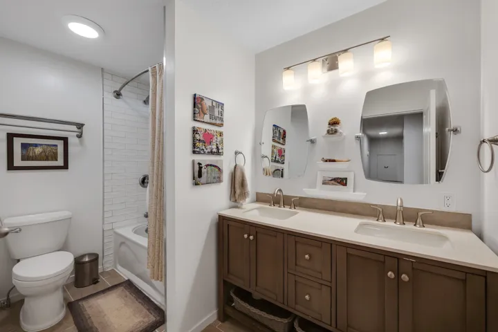 Full bath featuring double vanity and shower / tub combination