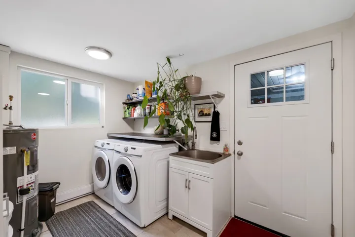 Laundry room featuring water heater and washing machine and clothes dryer
