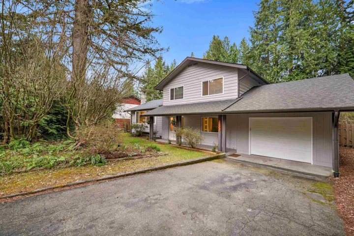Two-story residence featuring light gray siding, a dark gray asphalt shingle roof, and a covered entry
