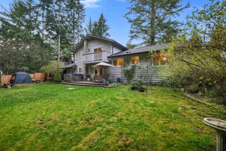 Back of property featuring a deck and a balcony
