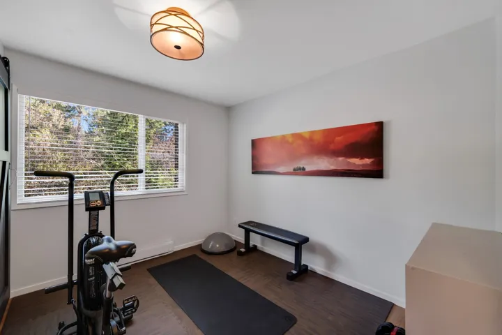 Exercise area with dark wood-style floors and baseboard heating
