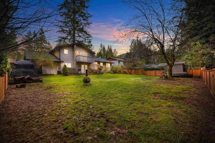 Yard at dusk featuring a fenced backyard, a wooden deck, and a storage shed