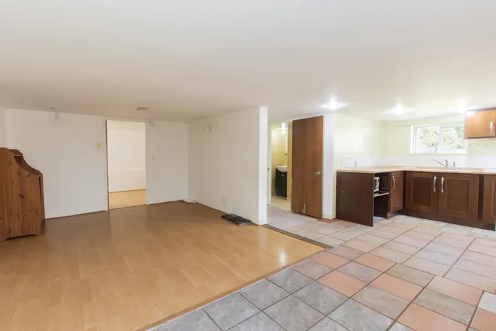 Kitchen with light countertops, light wood-style flooring, open floor plan, dark brown cabinetry, and stainless steel microwave
