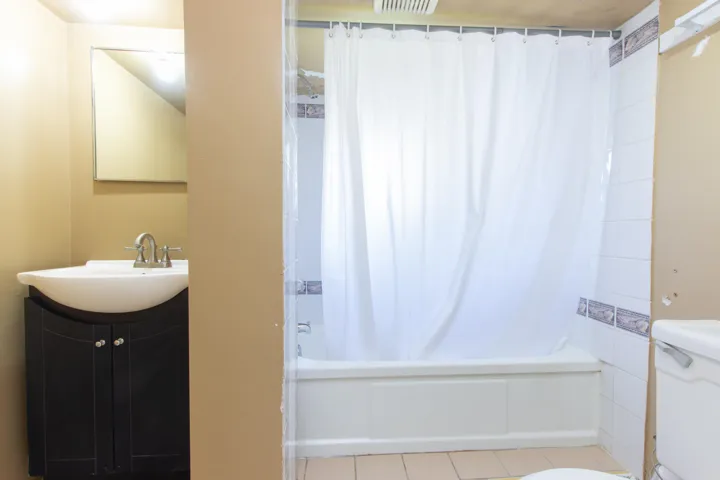 Full bathroom with vanity, shower / bath combination with curtain, and tile patterned floors