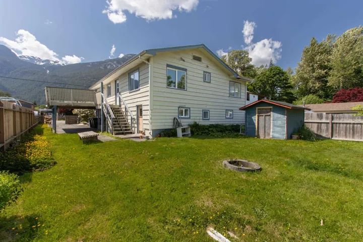 Back of house with a storage shed, a fire pit, a fenced backyard, stairway, and a deck with mountain view