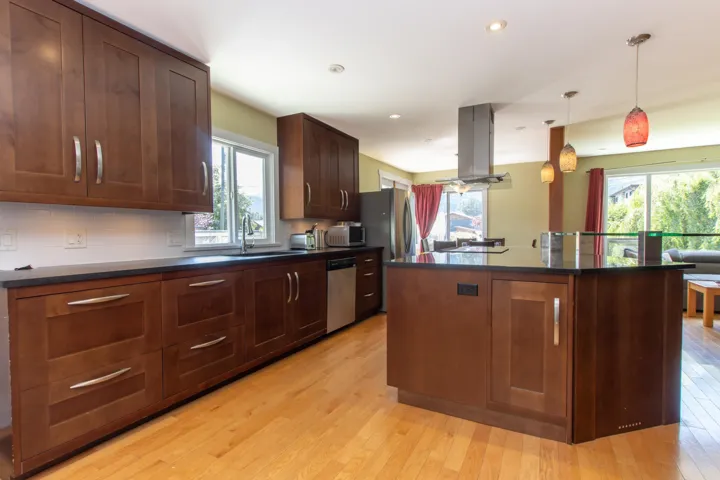 Kitchen with island exhaust hood, dark countertops, stainless steel appliances, healthy amount of natural light, and recessed lighting