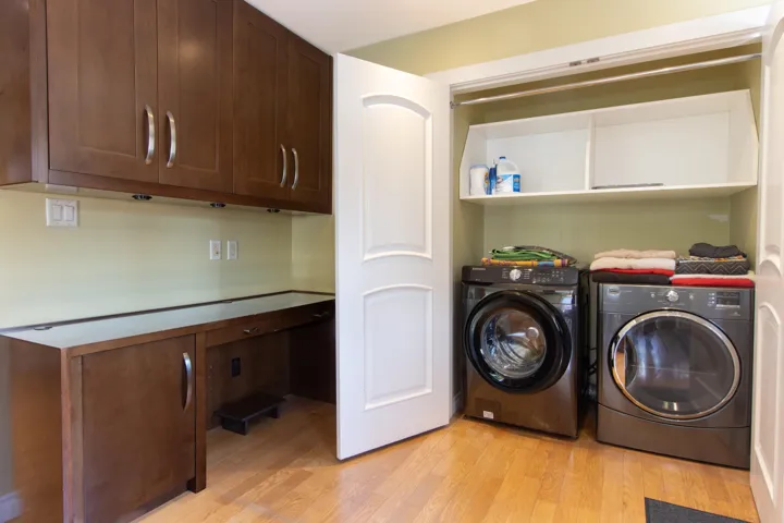 Washroom with cabinet space, light wood-type flooring, and washer and clothes dryer
