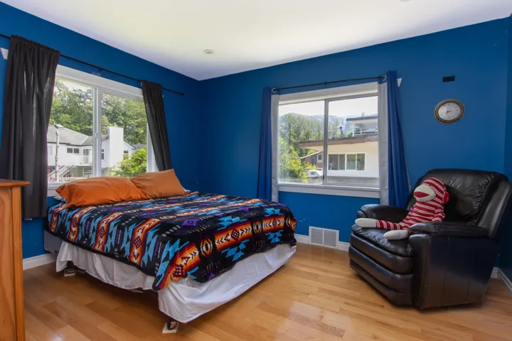 Bedroom featuring wood finished floors and multiple windows