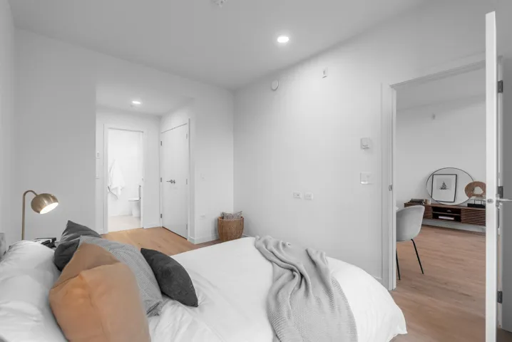 Bedroom with light wood-type flooring, ensuite bath, recessed lighting, and a closet