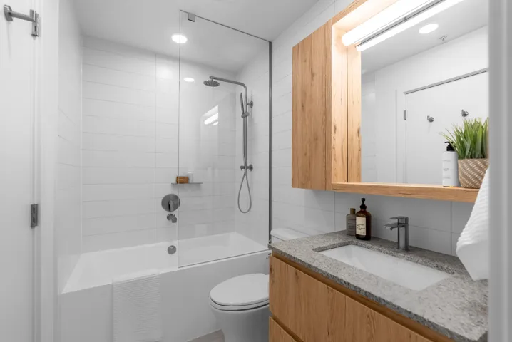 Bathroom with vanity,  shower combination, and recessed lighting