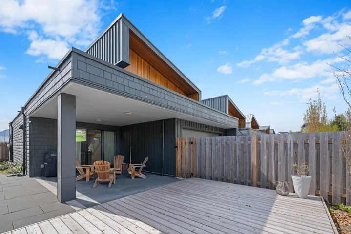 Wooden terrace with a garage, a patio area, and fence
