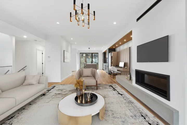 Living room featuring recessed lighting, light wood finished floors, a glass covered fireplace, and a chandelier