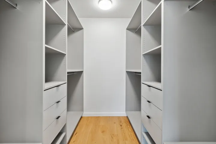 Walk in closet with light wood-style floors