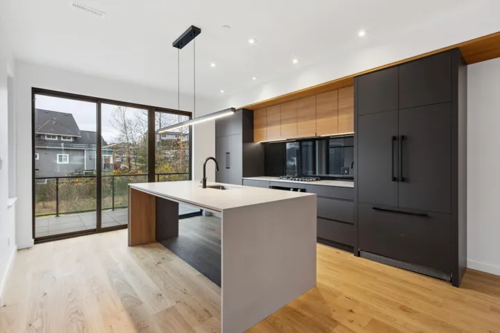 Kitchen with a kitchen island with sink, modern cabinets, hanging light fixtures, gray cabinets, and recessed lighting