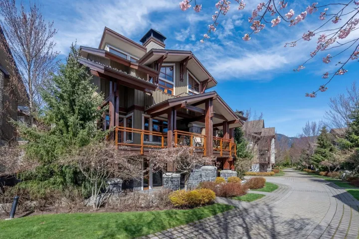 Back of property with a mountain view, a porch, and a chimney