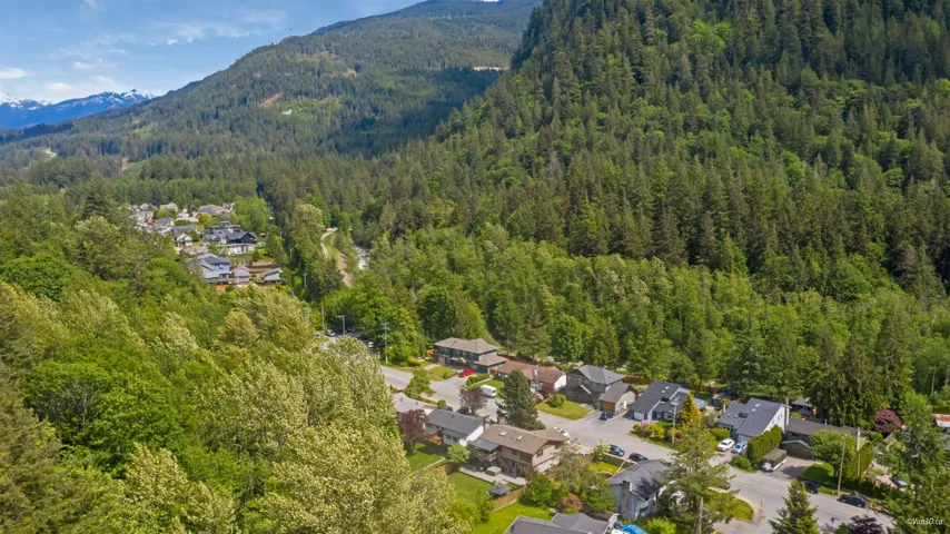 View of property location with a heavily wooded area, a mountain backdrop, and nearby suburban area