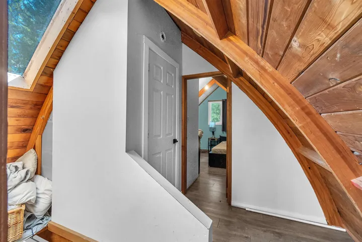 Curved wood-finish ceiling beams with slatted wood-finish ceiling panels