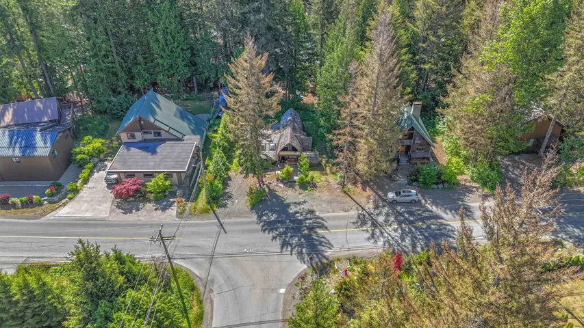 Residential property with a multi-level roofline, surrounded by mature evergreen trees