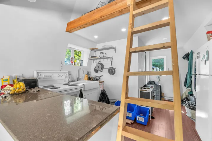 Kitchen area featuring a built-in counter, white electric range, farmhouse-style sink, and recessed lighting