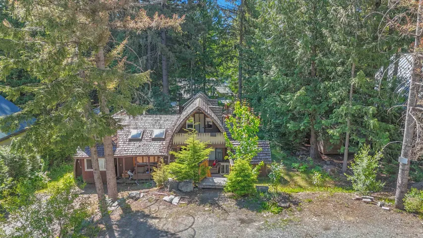 Distinctive A-frame style home featuring a wood shingle roof, multiple skylights, and an upper-level balcony