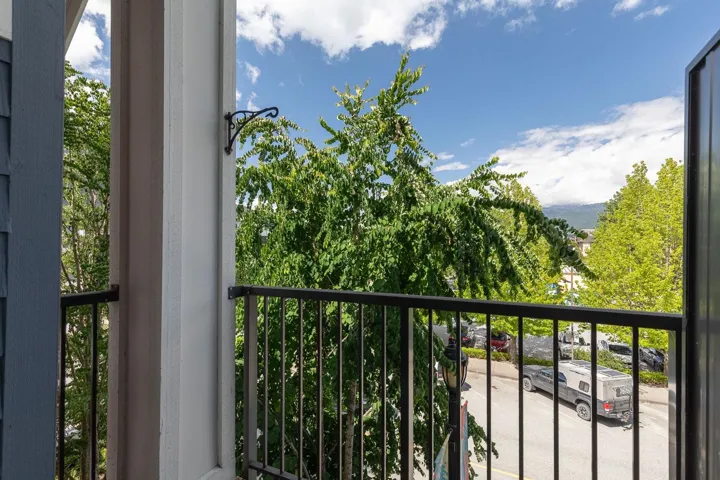 Balcony featuring black metal railings and a decorative iron bracket