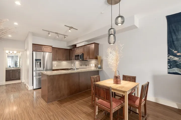 Open-concept living space featuring wood-finish flooring, recessed lighting, and a modern kitchen
