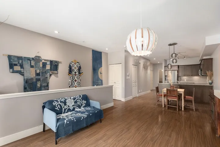 Open concept living space featuring wood-finish flooring, recessed lighting, and a contemporary pendant light fixture