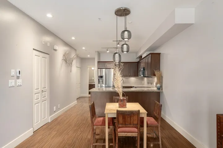 Open-concept living space featuring wood-finish flooring, recessed lighting, and a modern kitchen