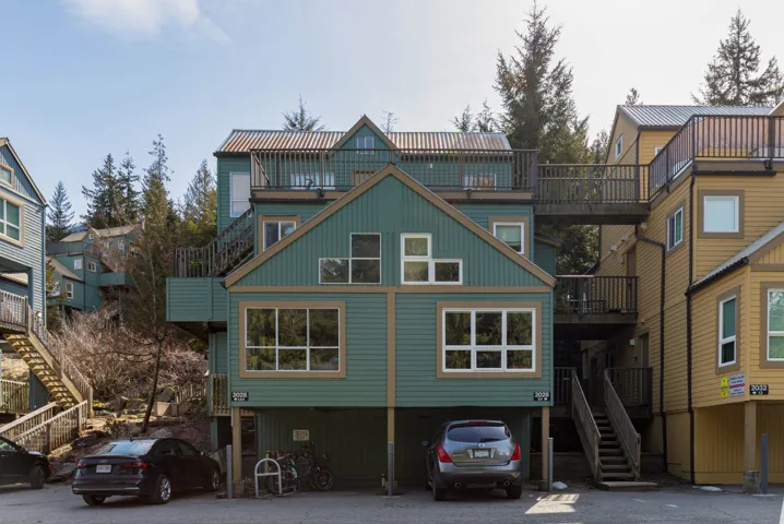 Rear view of property with stairway and a carport