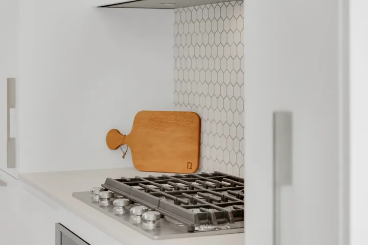 Laundry area with stacked washing machine and dryer and light tile patterned floors