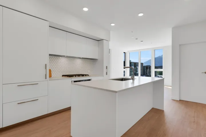 Kitchen with modern cabinets, white cabinetry, light wood-style flooring, tasteful backsplash, and recessed lighting