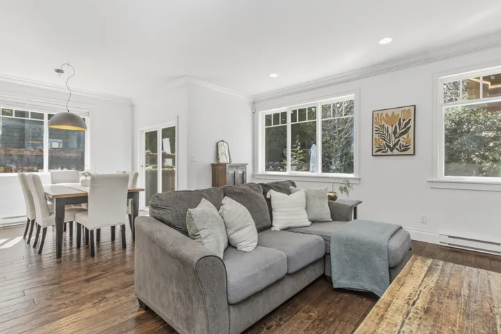 Living room featuring dark wood-style floors, crown molding, a baseboard radiator, and recessed lighting