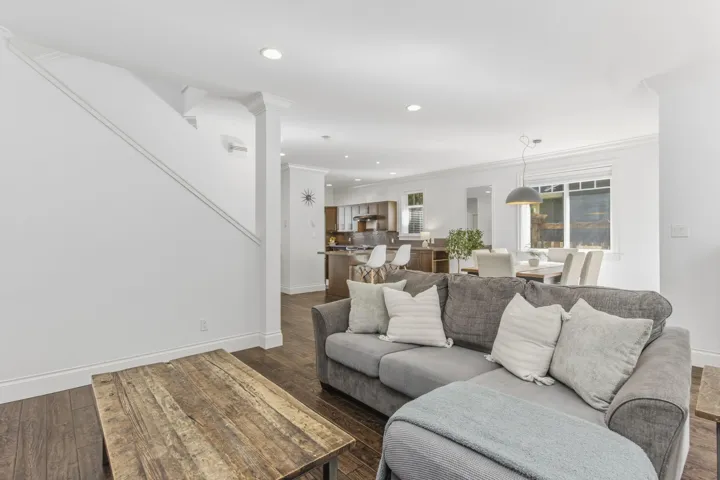 Living room featuring dark wood-style flooring, ornamental molding, and recessed lighting