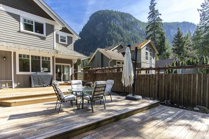 Wooden terrace with outdoor dining area, grilling area, and a mountain view