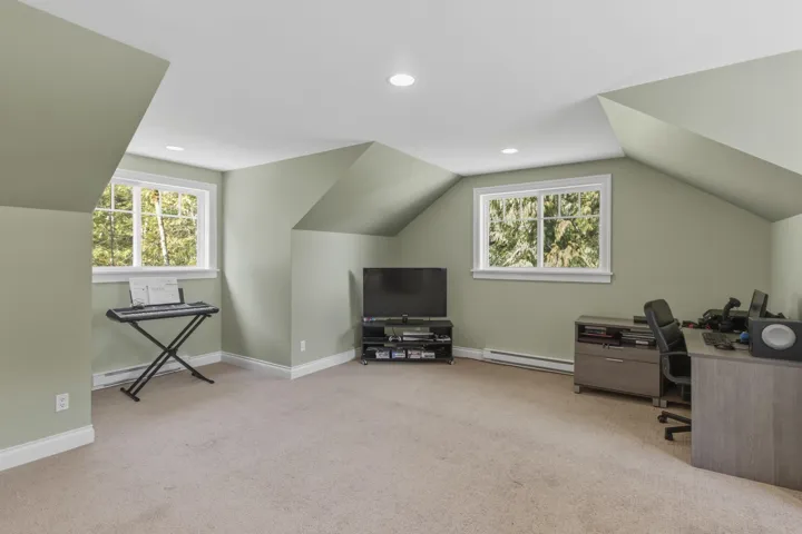 Home office with light colored carpet, a baseboard radiator, vaulted ceiling, and recessed lighting